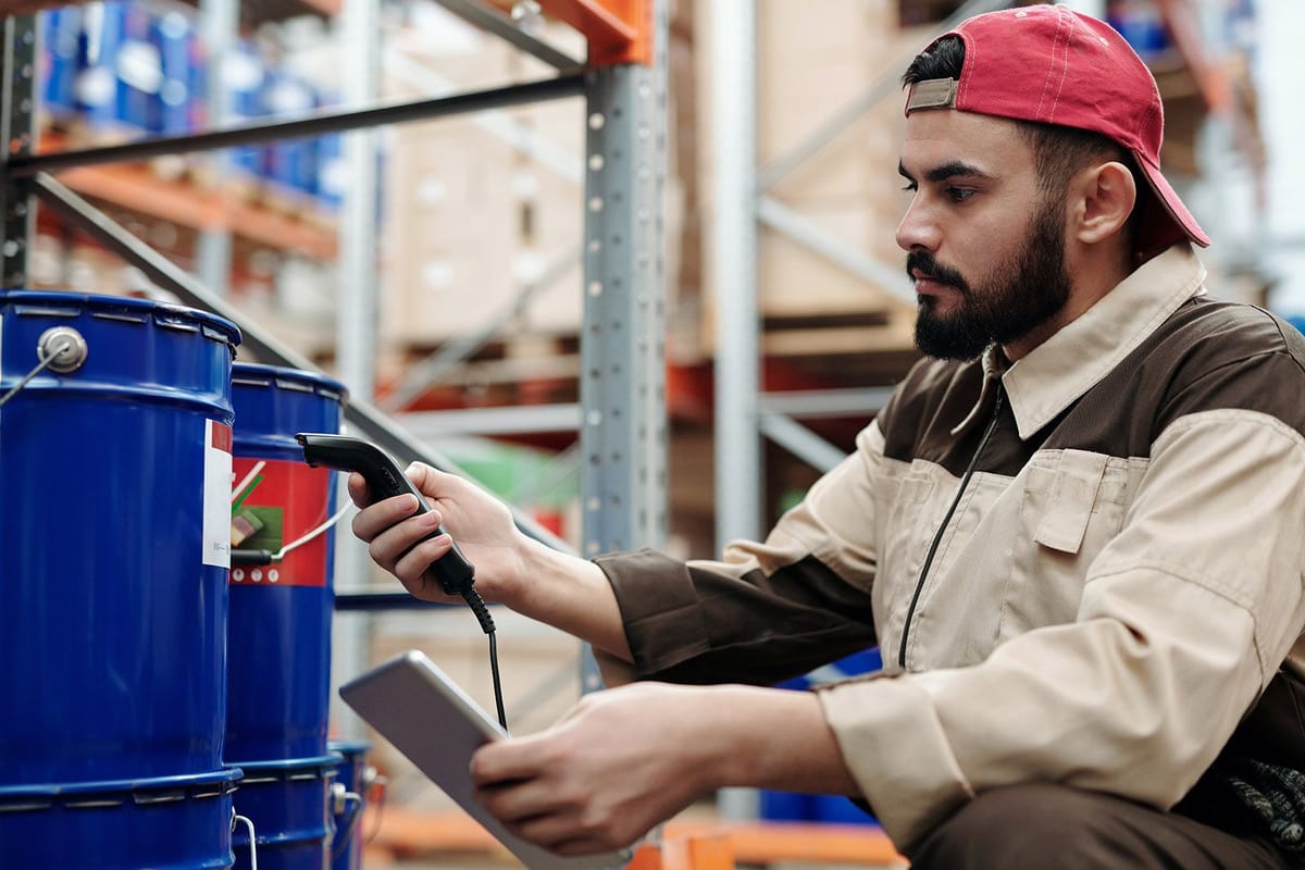 Hardware store employee scans gallons of pain to his tablet.