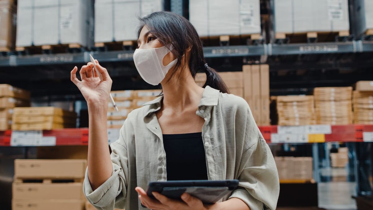 A female inventory manager checking qunatities of inventories to reorder in a warehouse