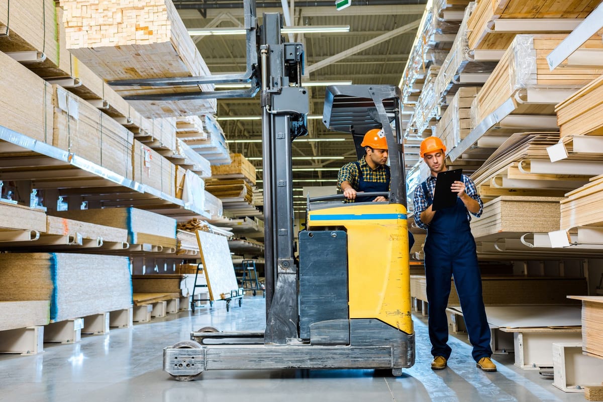 Two workers working in a lumber warehouse