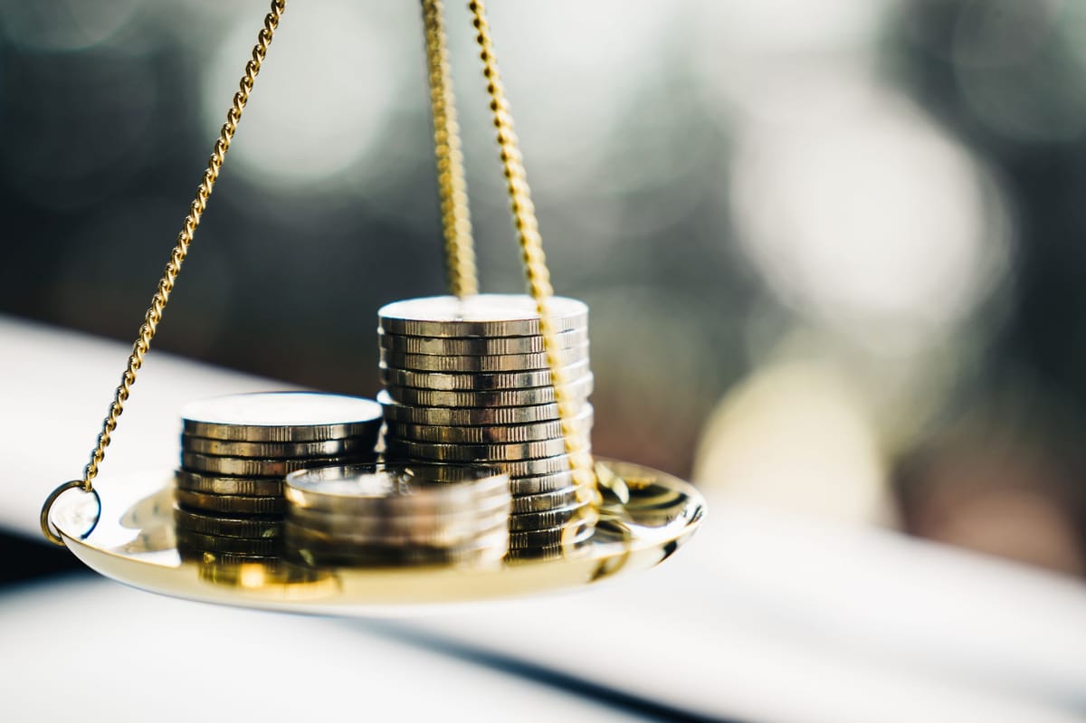 The image of coins stacked on a weighing scale