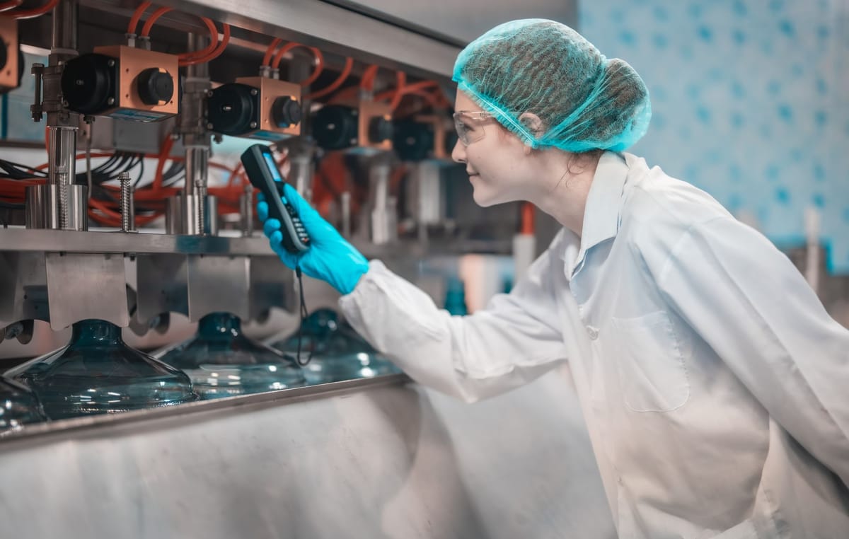 A researcher pointing a sensor towards a tube.