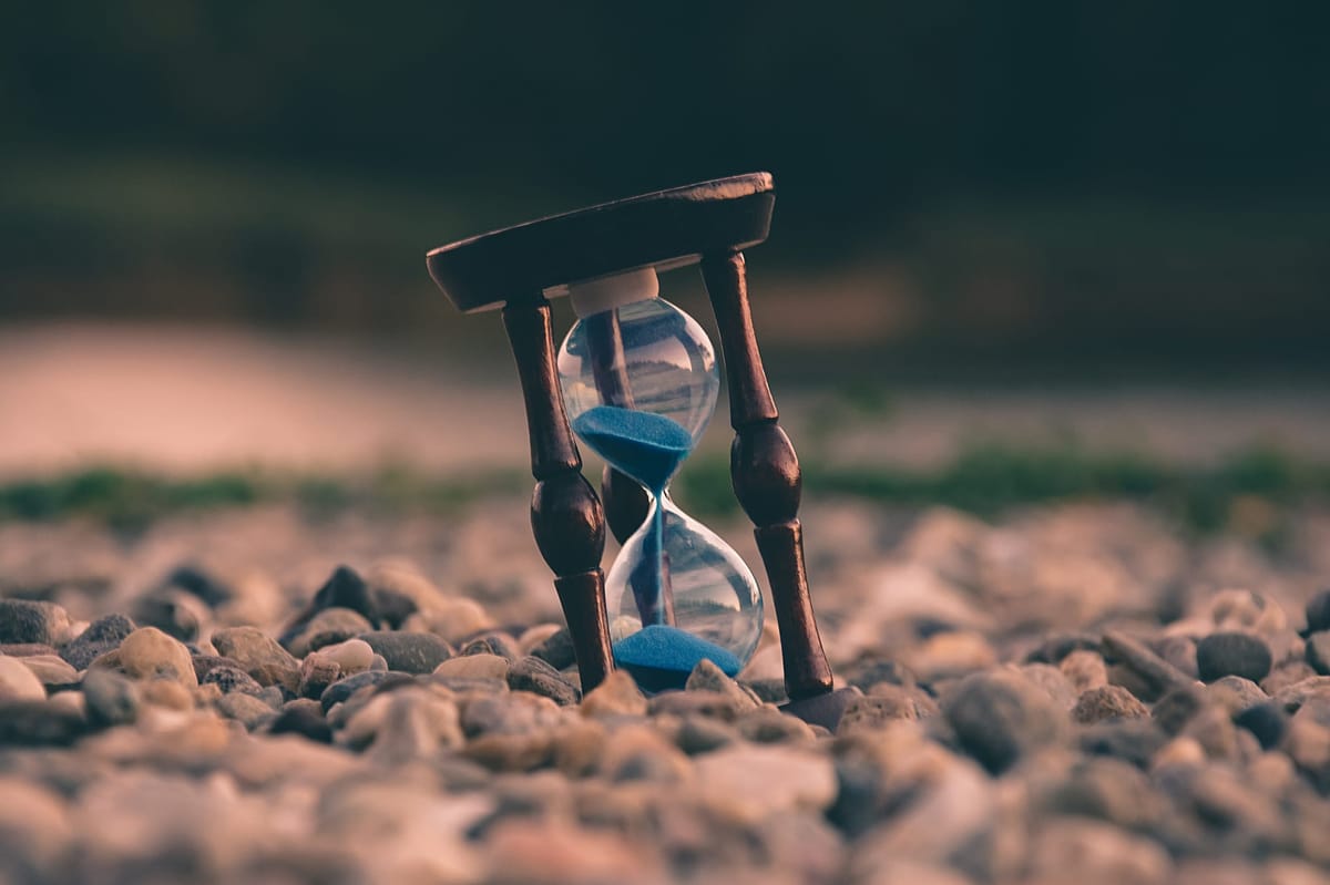 An hourglass sitting on top of small rocks.