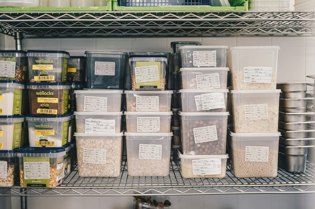 Kitchen supplies and ingredients neatly arranged on shelves and in storage bins