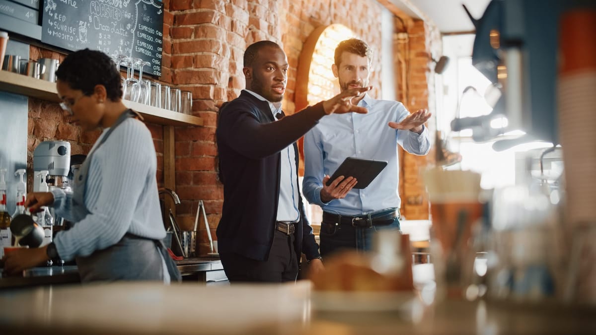 Restaurant Owner discussing lean inventory practices with staff member