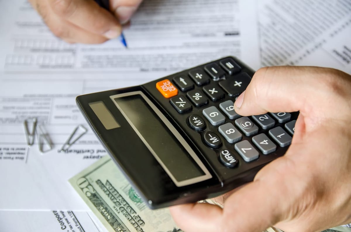 Businessman calculating and checking tax with calculator