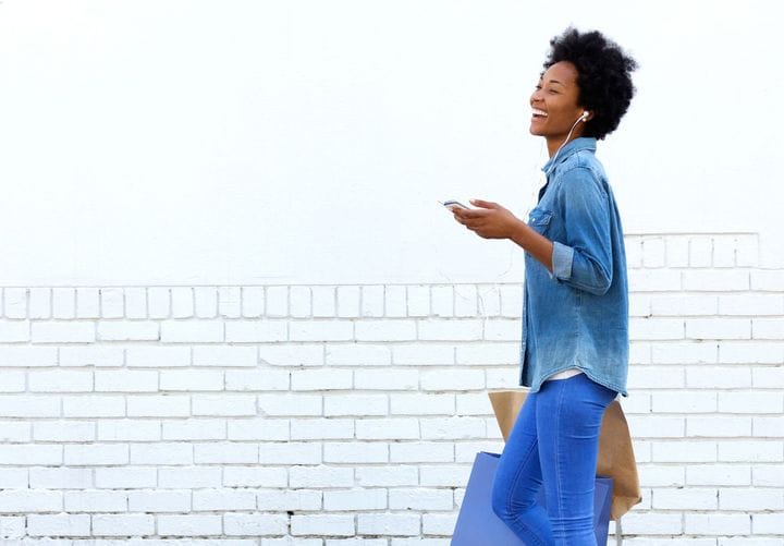 A female holding shopping bags in her hands while listening to music 