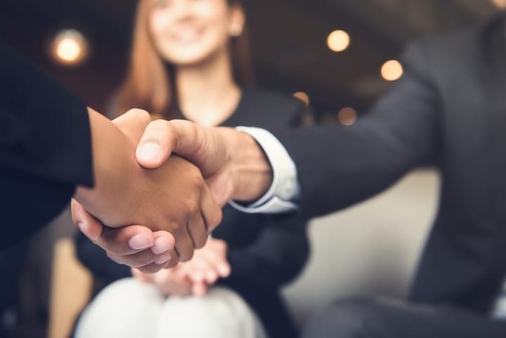 Men in suits shaking hands.