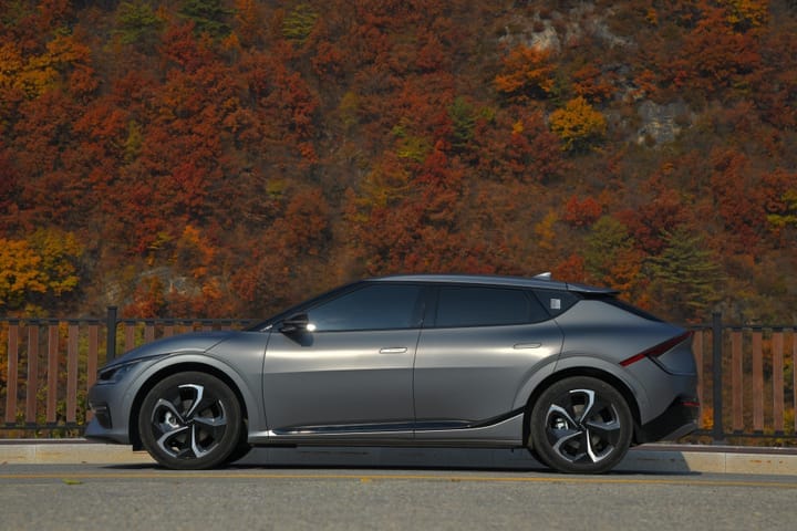 Kia EV6 standing next to autumn leaves.