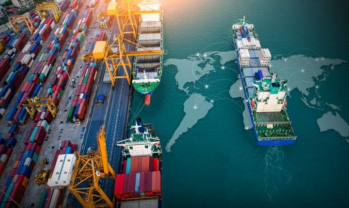 A dock with cranes, container boxes, and vessels.