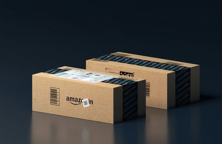 Two Amazon-branded cardboard boxes with Prime tape and shipping labels, placed against a dark background.