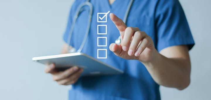 General practitioner (GP) hand using a stylus pen to check box on medical checklist
