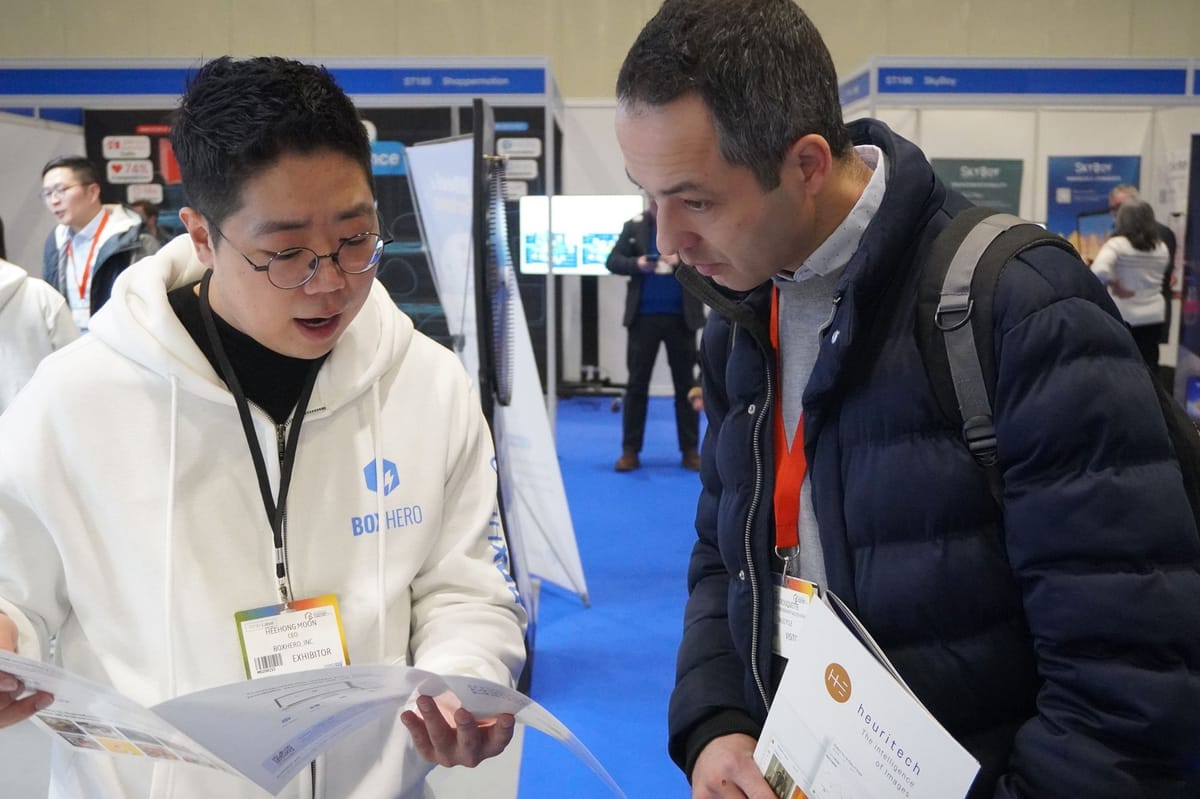 Miembros del equipo de BoxHero realizando una demostración para un visitante del stand