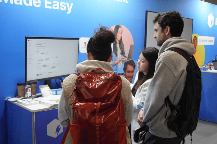 Una integrante del equipo demostrando las funciones de BoxHero a los visitantes del stand
