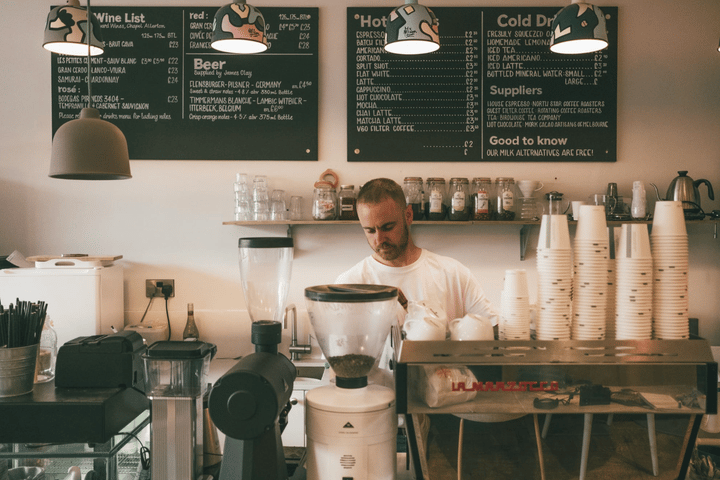 Barista trabajando detrás del mostrador de una cafetería.