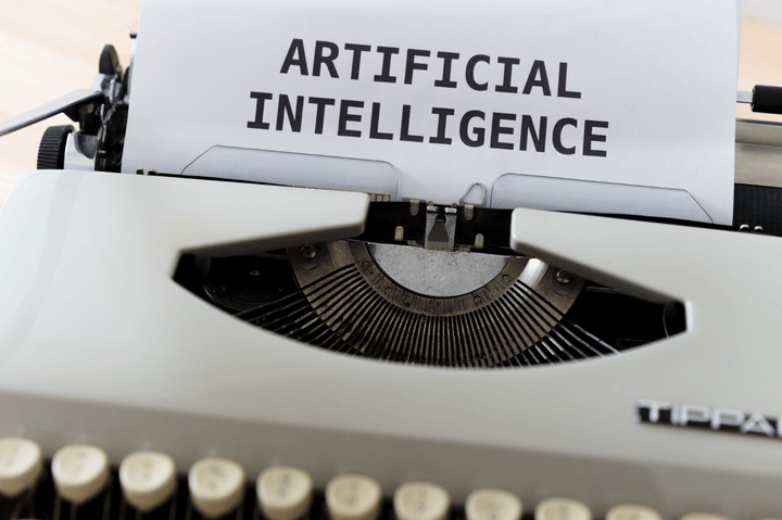 Máquina de escribir con una hoja en la que aparece escrito ‘ARTIFICIAL INTELLIGENCE’.