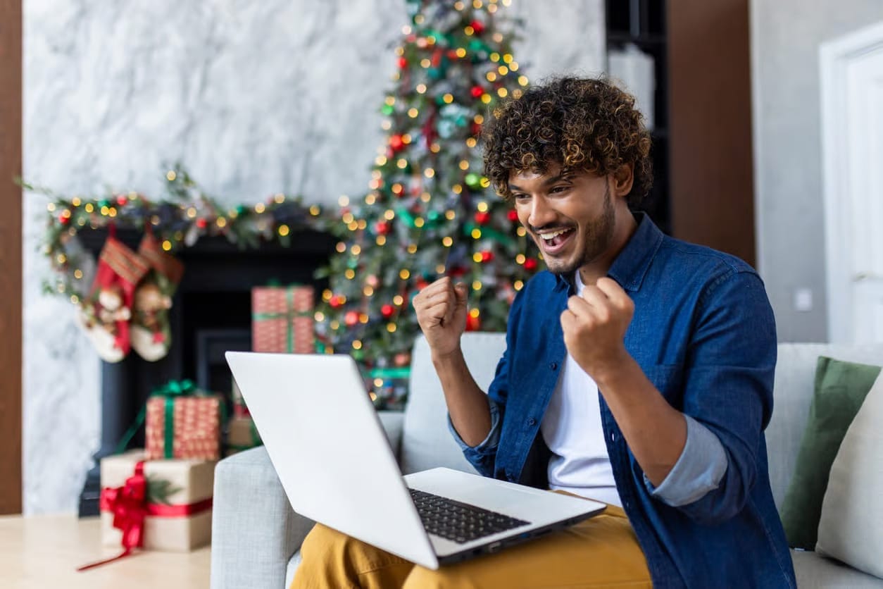 Pria bekerja dengan laptop di sofa ruang tamu saat musim liburan