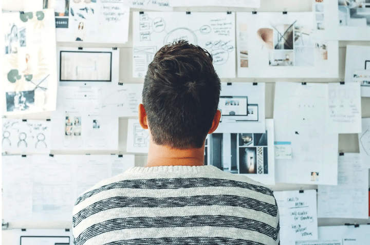 Hombre mirando un panel con muchos diseños