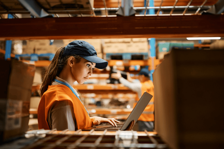 Una joven utiliza un sistema de gestión de inventario para buscar productos en el almacén