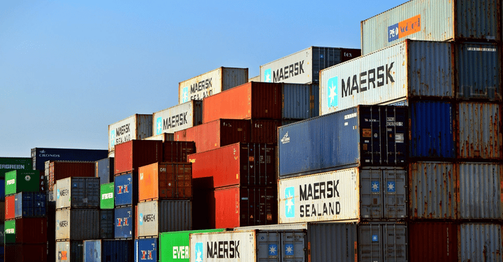 Contenedores acumulados en un almacén, reflejando exceso de inventario