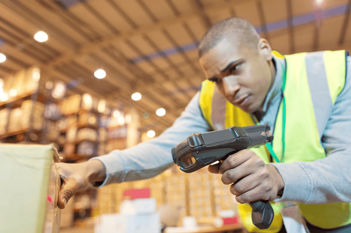 Personal del almacén escaneando cajas con un lector de códigos de barras