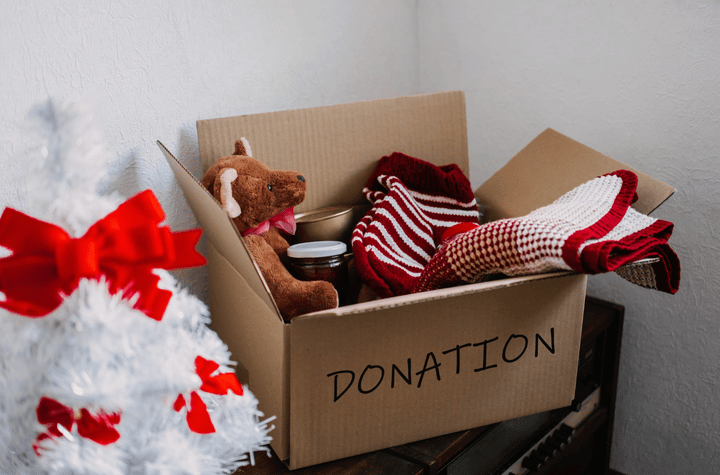 Una caja de donaciones llena de juguetes, ropa y artículos, lista para la temporada de generosidad