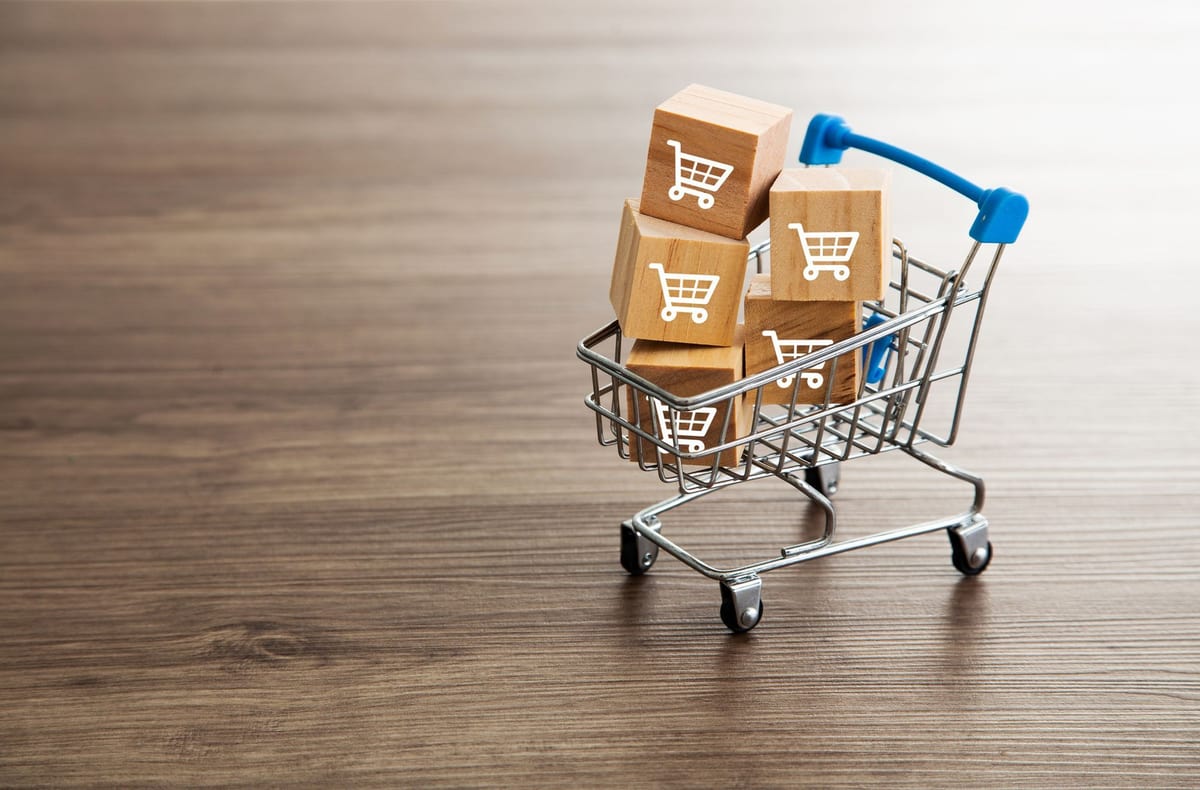 A miniature shopping cart filled with boxes of products.&nbsp;