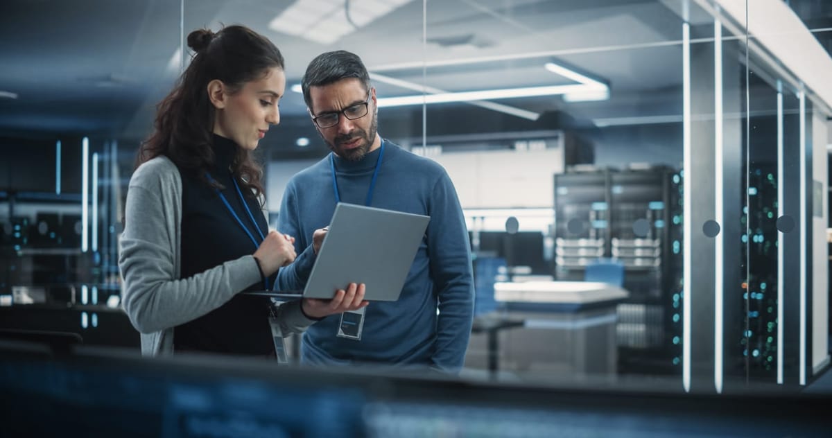 Portrait of Two Female and Male Engineers Using Laptop Computer to Analyze and Discuss Work