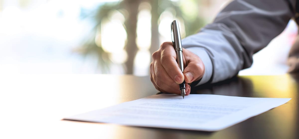 Businessman Signing An Official Document with Pen and Paper