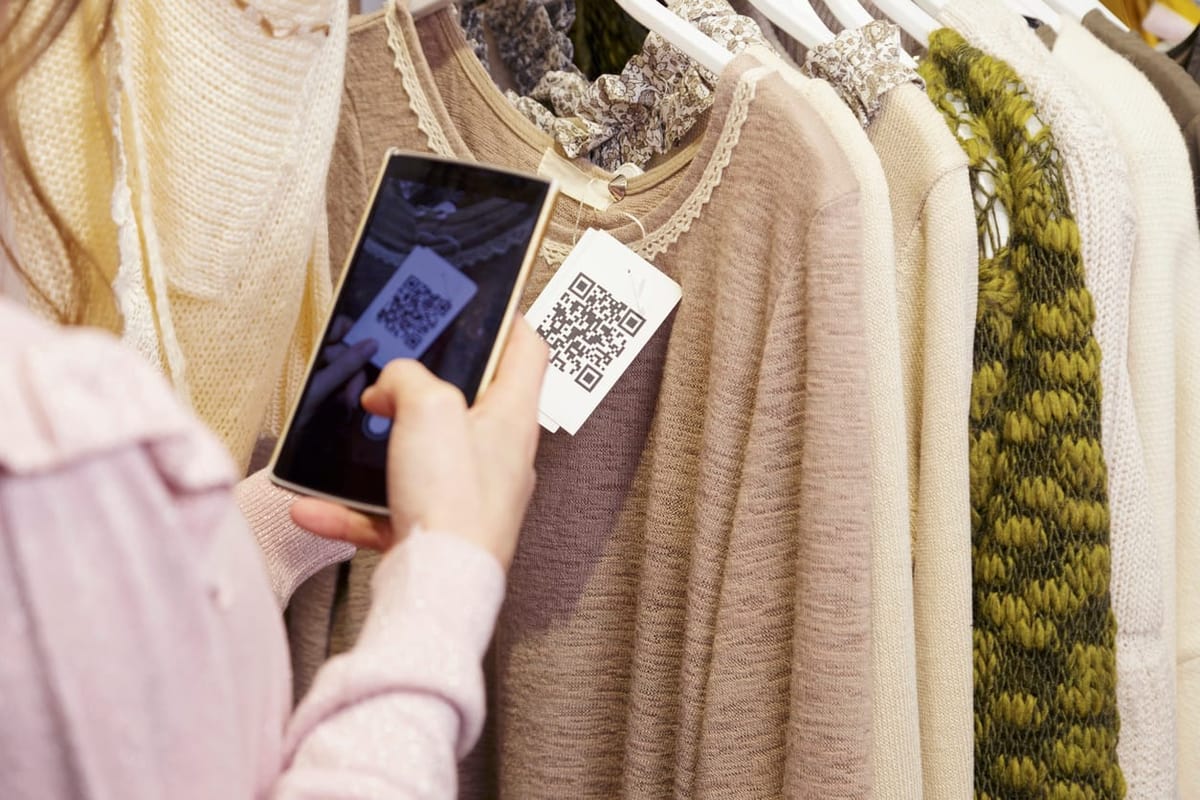 Woman scanning a QR code with her smart phone from a label in a clothing store.