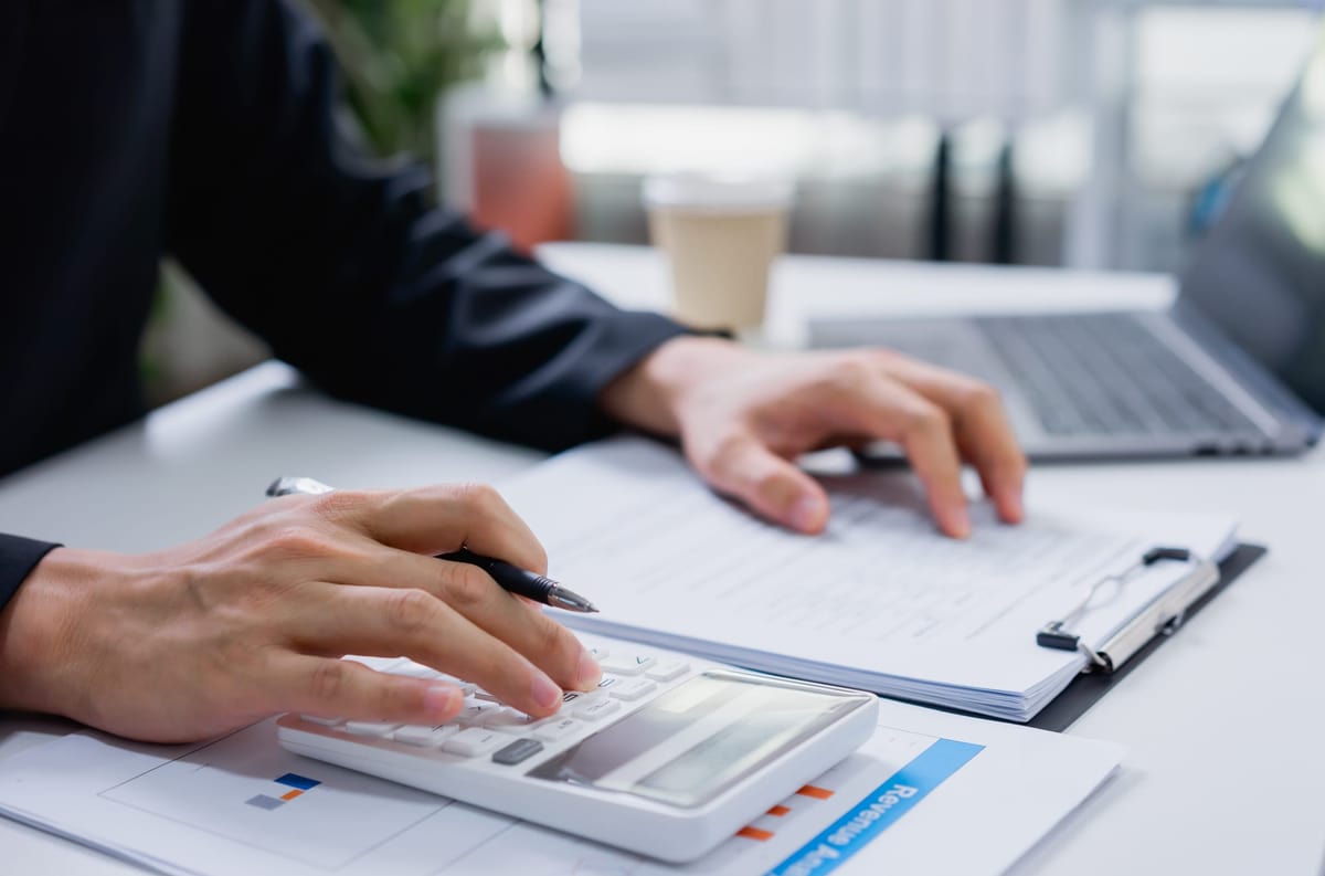 Close-up of a business professional using a calculator to analyze numbers and productivity