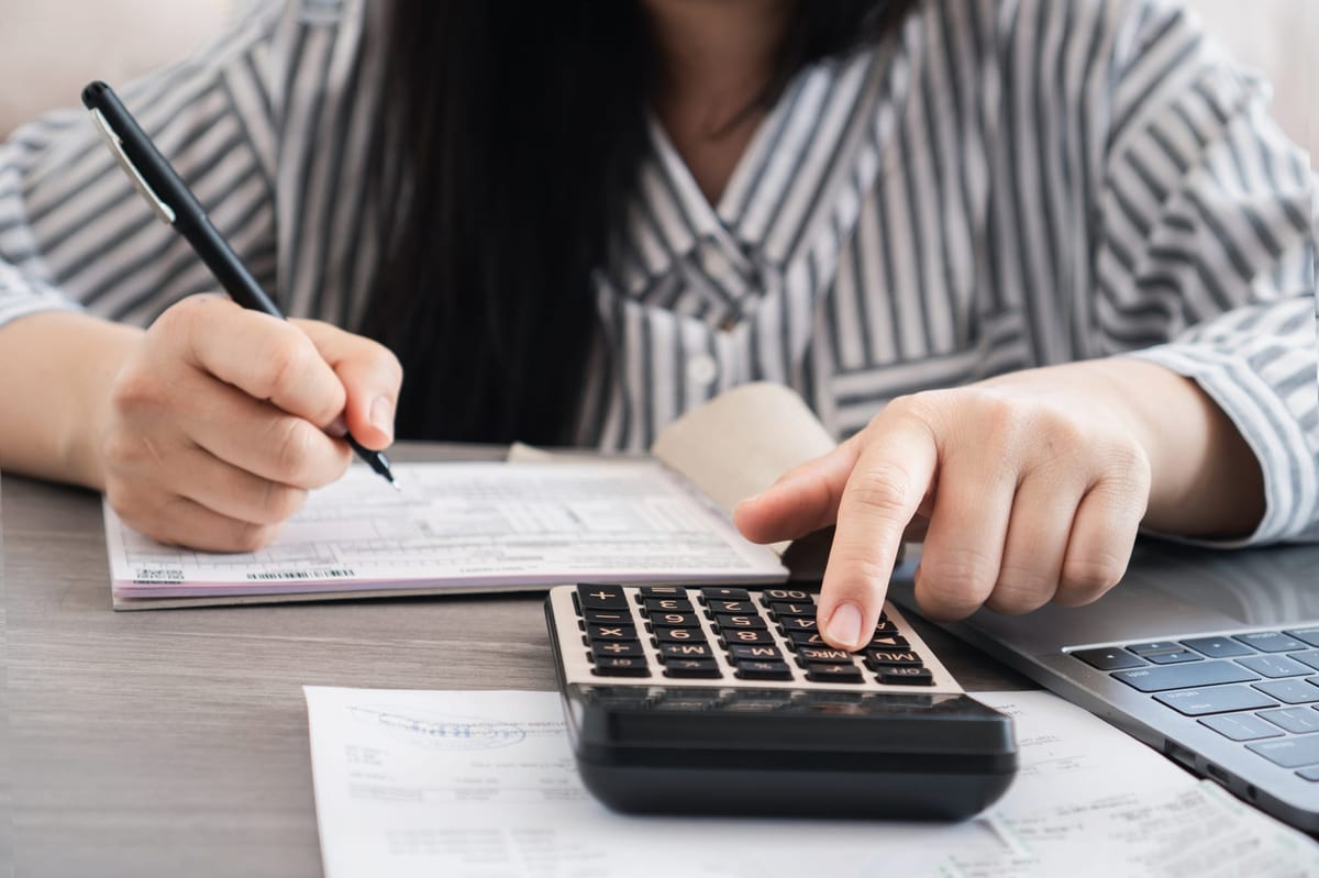 Businesswoman using a calculator and analyzing business credit sales, revenue, profit.