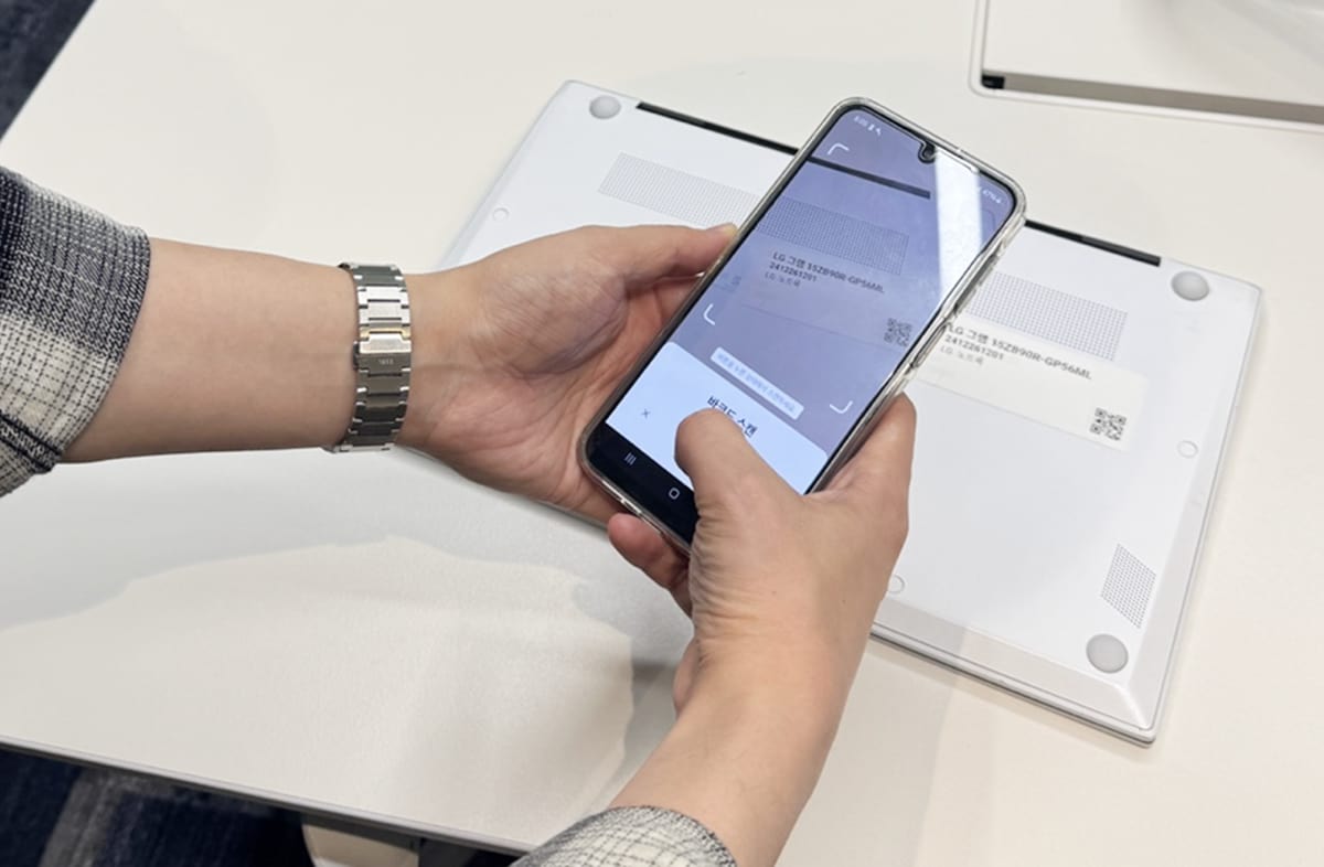 노트북에 부착된 자산 관리용 바코드를 박스히어로 모바일 어플로 스캔하는 이미지