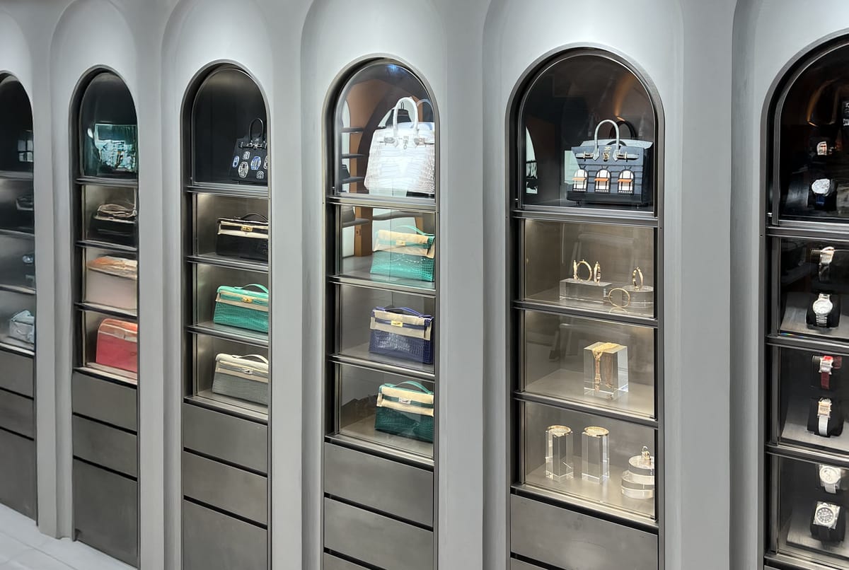 아치형 진열장 안에 고급 가방, 시계, 주얼리 등이 전시된 매장 내부 모습